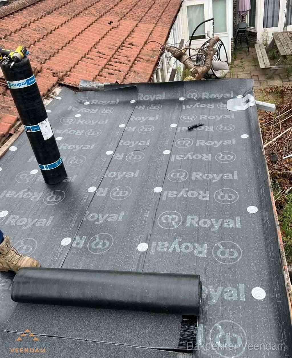 Plat dak met nieuwe bitumen dakbedekking en brandgereedschap in Veendam