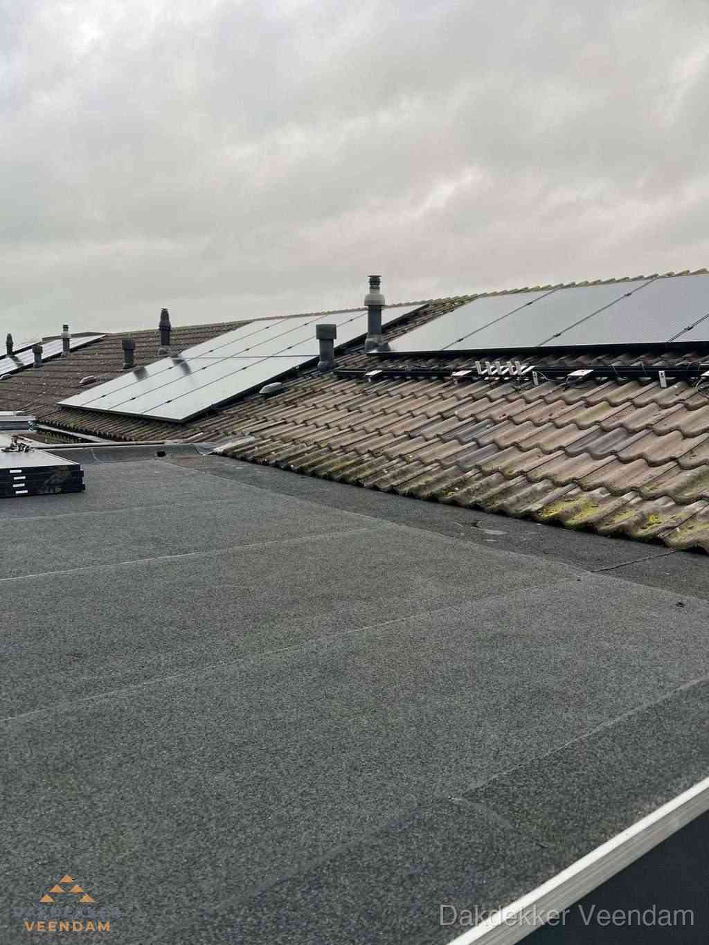 Plat dak inspectie met bitumen bedekking naast schuin pannendak in Veendam