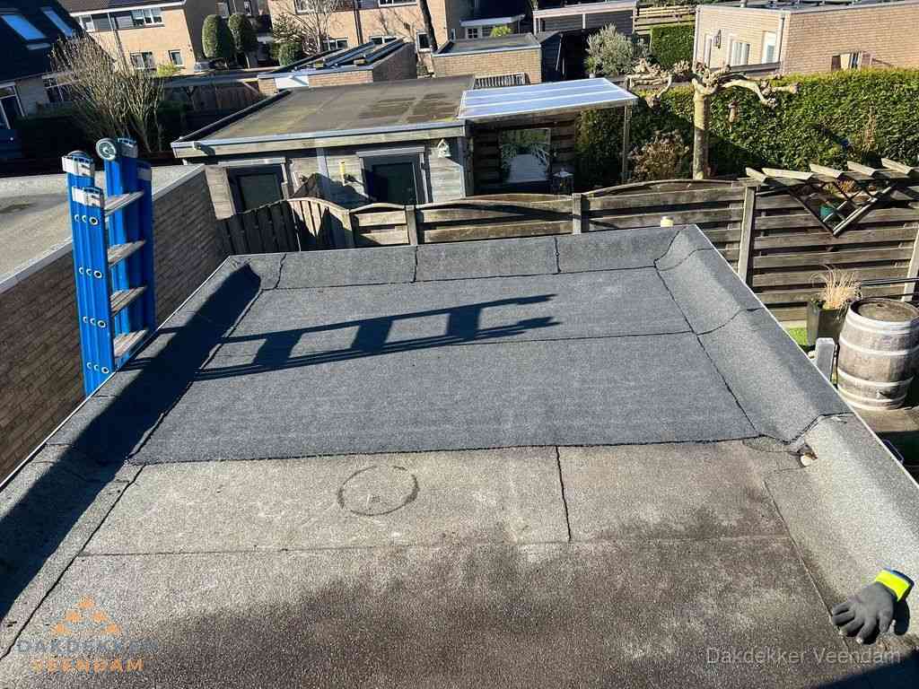 Dakdekker legt onderlaag op plat dak met houten constructie in Veendam