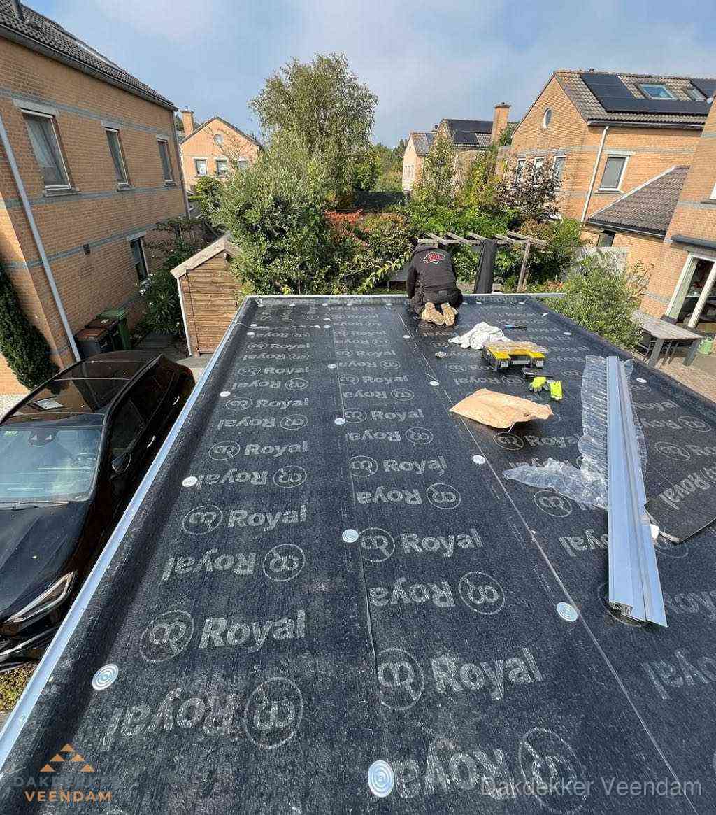 Dakdekker aan het werk op plat dak renovatie in Veendam