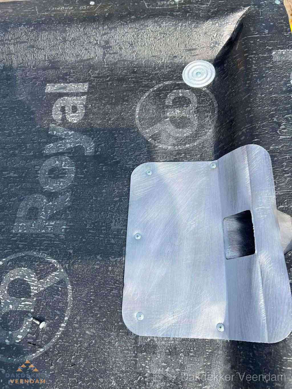 Dakdoorvoer met metalen afvoerplaat op bitumen dak in Veendam