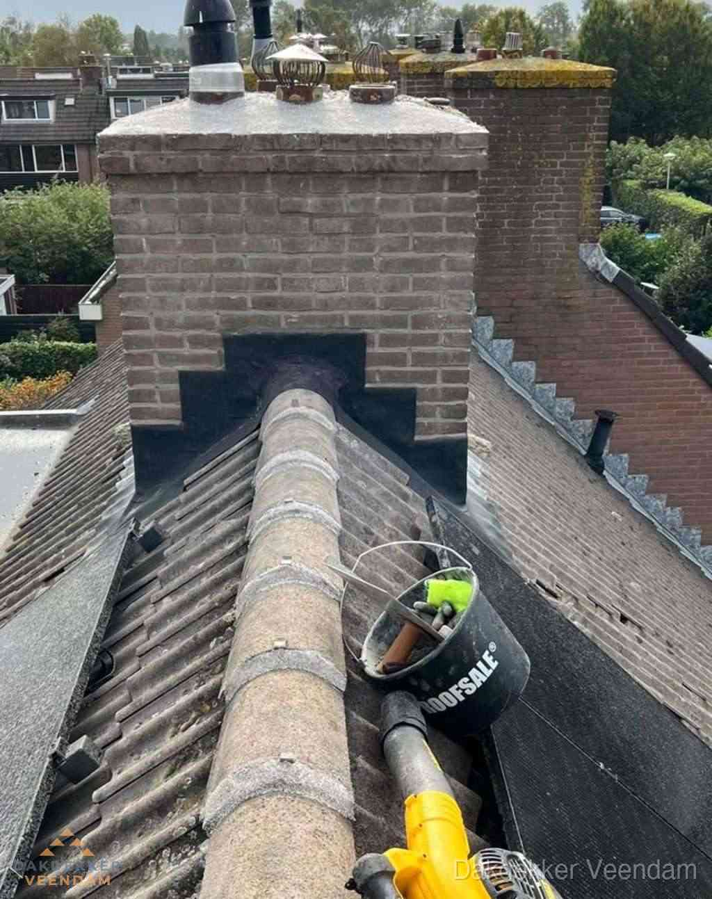 Dakdekker repareert bitumen dakleer bij dakdoorvoer in Veendam
